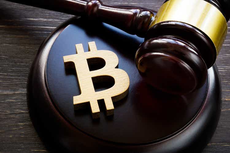Bitcoin symbol and gavel to regulate cryptocurrencies market.