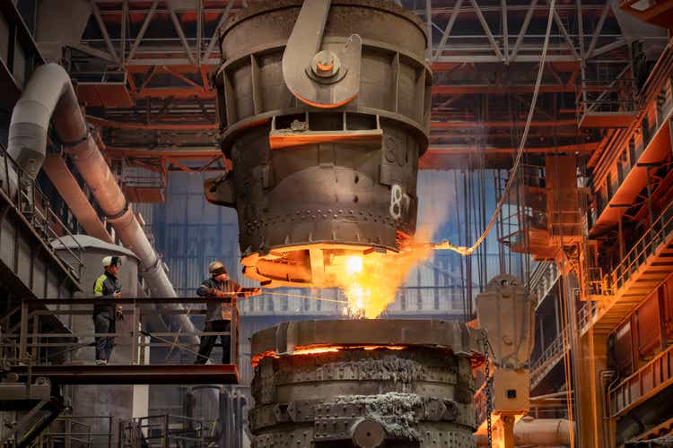 Steelworker starting molten steel pour in steelworks
