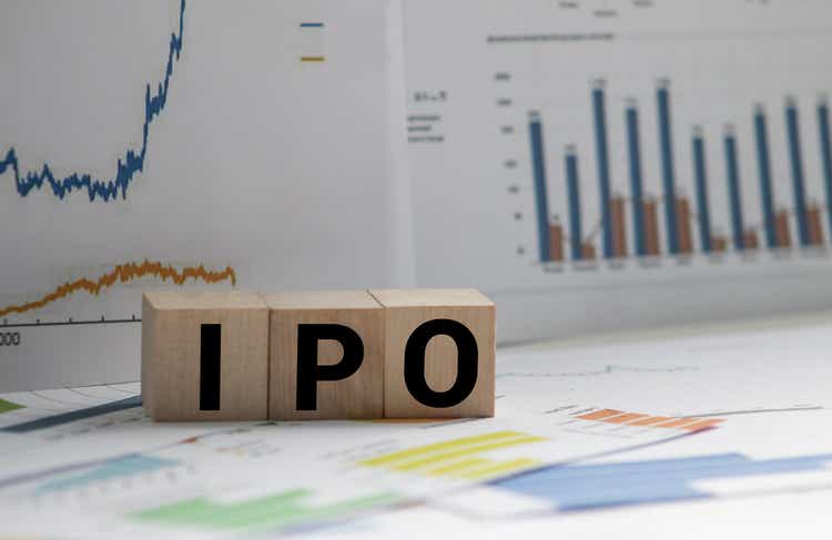A Notebook with Business notes initial coin offering ICO vs IPO Initial Public Offering with office tools on yellow blue background. Concept of the choice of IPO or ICO